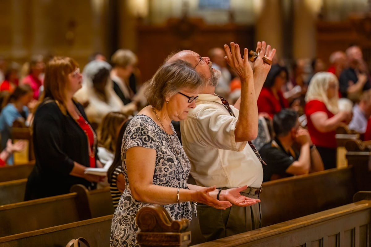 People engaged in prayer and singing within the interior of the church